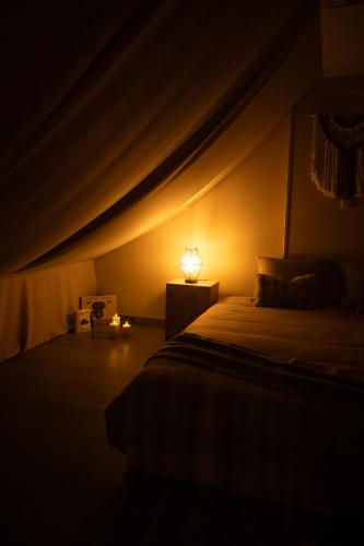 a bedroom with a bed with a lamp on it at Loft avec Spa Privatif in Frameries