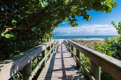 een houten promenade die naar het strand leidt bij 400 South - Unit E in Cocoa Beach