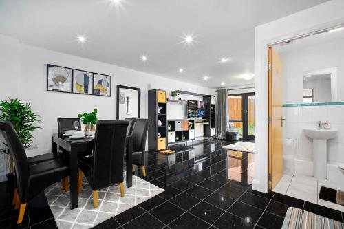a dining room with a table and black chairs at Spacious 4-bedroom House in Birmingham near city centre with Parking and ideal for families and groups in Birmingham