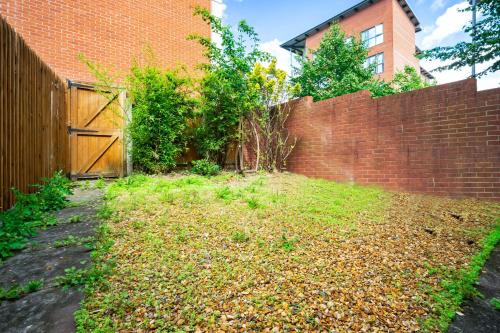 a backyard with a brick wall and a fence at Spacious 4-bedroom House in Birmingham near city centre with Parking and ideal for families and groups in Birmingham