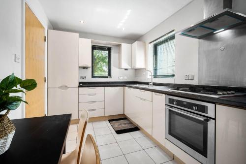 a kitchen with white cabinets and a black stove top oven at Spacious 4-bedroom House in Birmingham near city centre with Parking and ideal for families and groups in Birmingham