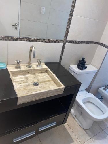 a bathroom with a wooden sink and a toilet at summer house in La Porteña