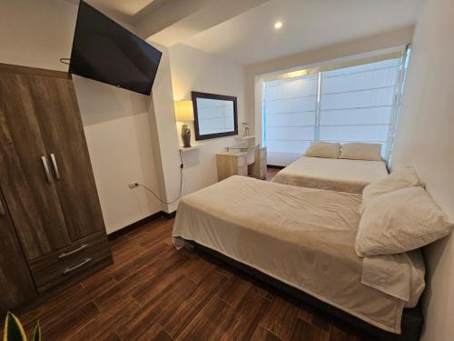 皮门特尔Hospedaje en Pimentel, playa的一间卧室，配有两张床和一台平板电视