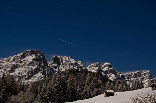 a snow covered mountain range with trees and houses at Alpin Chalet Frenademetz in San Martino in Badia