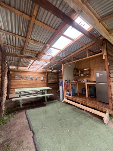 a large wooden building with a picnic table in it at Glamping Peumayen carpintero in Llanquihue