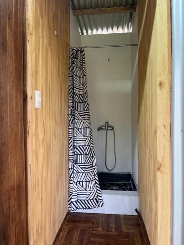 a bathroom with a shower with a zebra shower curtain at Glamping Peumayen carpintero in Llanquihue