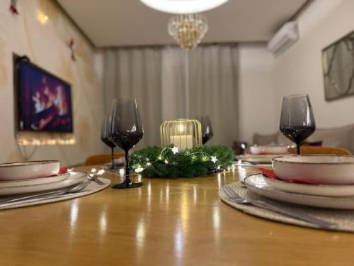 a table with plates and wine glasses on it at Belgrade Waterfront - Beograd na vodi Scala in Belgrade