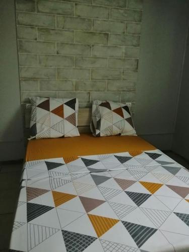 a bedroom with a bed with a quilt on it at La Parenthèse Verte à ducos in Ducos
