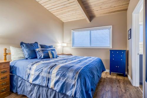 a bedroom with a blue bed and a window at Sea-Esta in Lincoln City