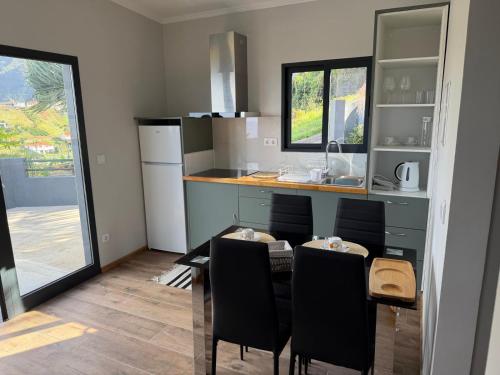 eine Küche mit Tisch und Stühlen und einer Theke in der Unterkunft Casa Rosa in Porto da Cruz