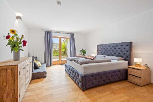 Schlafzimmer mit einem Kingsize-Bett und einer Kommode in der Unterkunft Moderne Ferienwohnung mit Bergblick und großer Terrasse nahe Simssee, Chiemsee und Autobahn A8 Salzburg - München in Rohrdorf