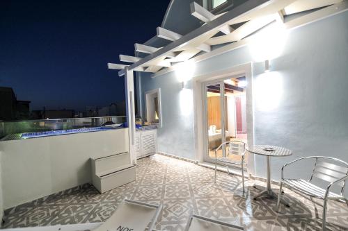 a balcony with a table and chairs on a building at Asterolithos in Fira