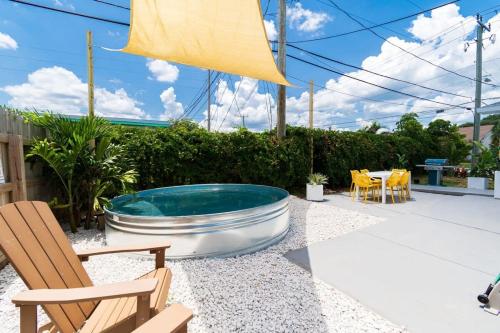a patio with a hot tub and chairs and tables at THE JUNI Studio Surf Paradise in Heart of Cocoa Beach in Cocoa Beach