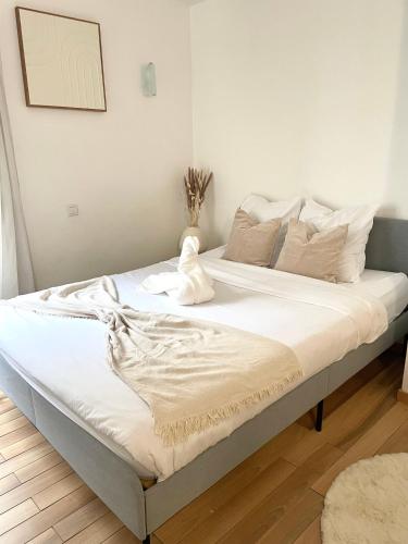ein Bett mit weißen Laken und Kissen in einem Zimmer in der Unterkunft Le Michel Ange in Courbevoie