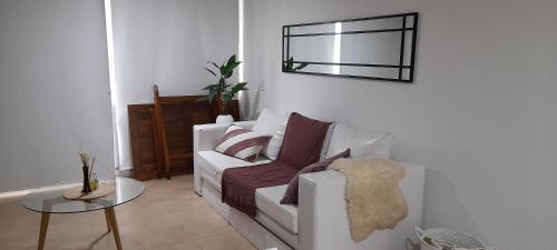 a living room with a white couch and a table at Apartmento, Punta 30 Complejo in Mar Azul
