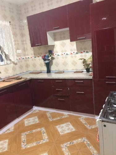 una cucina con armadi marroni e vaso di fiori di Luxurious Chantan Apartment a Chantan