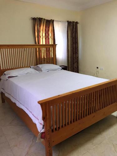 un grande letto in legno in una camera da letto con finestra di Luxurious Chantan Apartment a Chantan