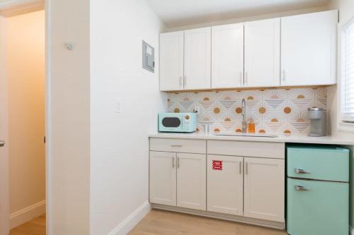 Una cocina con gabinetes blancos y un microondas. en THE JUNI Stunning Studio Walk to Everything, en Cocoa Beach
