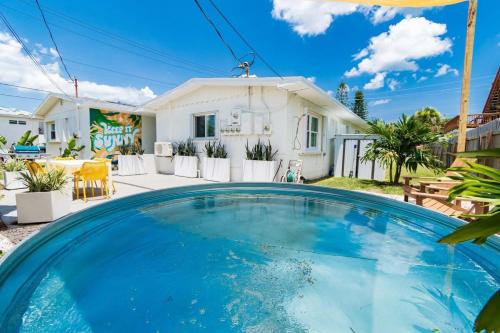 una gran piscina azul frente a una casa en THE JUNI Stunning Studio Walk to Everything, en Cocoa Beach