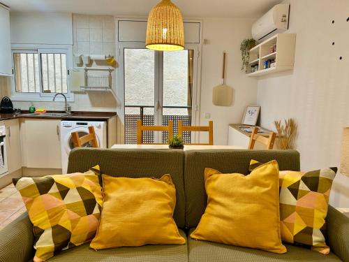 a living room with a couch with yellow pillows at Apartamento Sant Josep in Canet de Mar