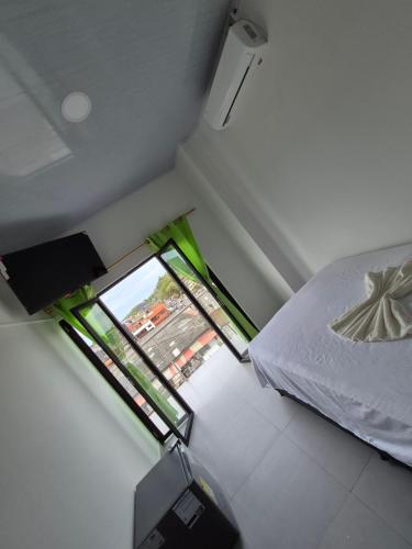 una piccola stanza con un letto e una finestra di APARTAHOTEL PUERTA DEl MAR a Necoclí