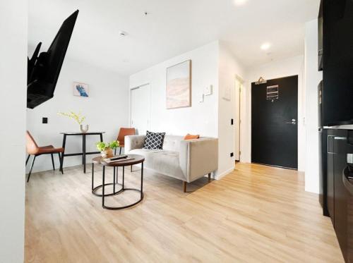 a living room with a couch and a table at VC Skytower view With Swimming pools & Suna Family Retreat in Auckland