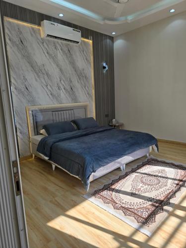 una camera con un grande letto in una stanza con un tappeto di Algharam resort a Ḩaḑīb