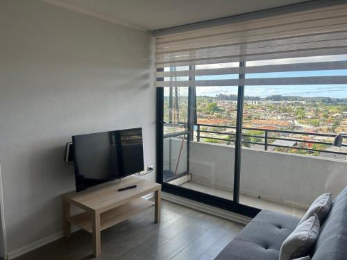 康塞普西翁Dpto Concepción Amoblado的一间带电视和大窗户的客厅