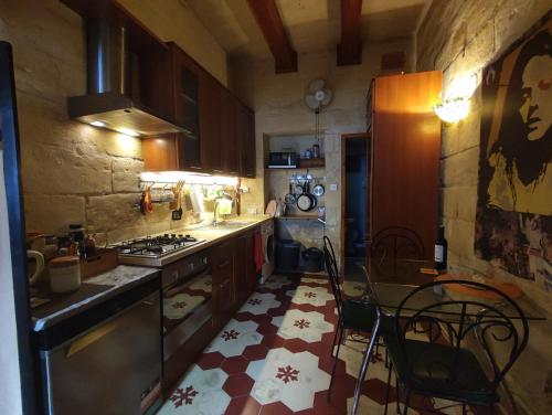 cocina con fogones, mesa y sillas en The Little Duke Residence, en Hamrun