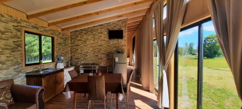 库拉考廷Cabaña 4 Acogedora en un entorno natural的厨房兼餐厅，配有桌椅