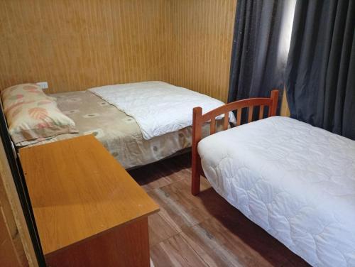 库拉考廷Cabaña 4 Acogedora en un entorno natural的有两张床和一张桌子的小房间