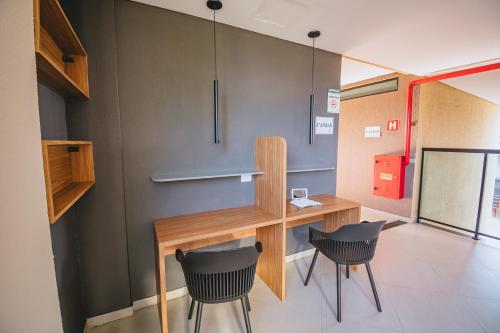 a room with a desk and two chairs at Condomínio encantador com piscina in Ipojuca