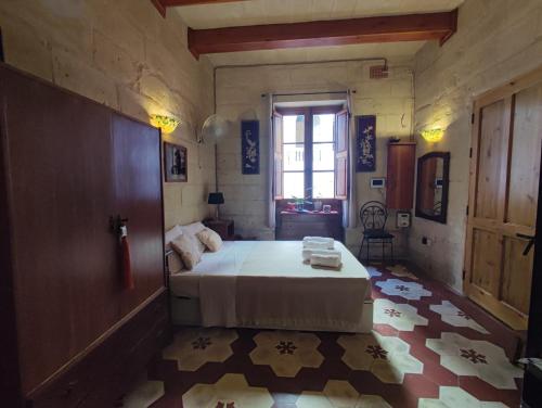 Un dormitorio con una cama grande y una ventana. en The Little Duke Residence, en Hamrun