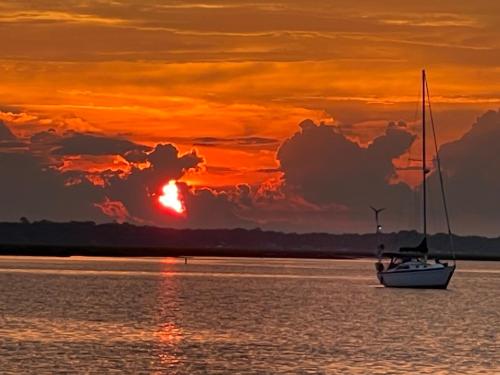 Un velero en el agua con una puesta de sol en Golf Cart to Beach , Pet Friendly, Fenced, Quiet, en Fernandina Beach