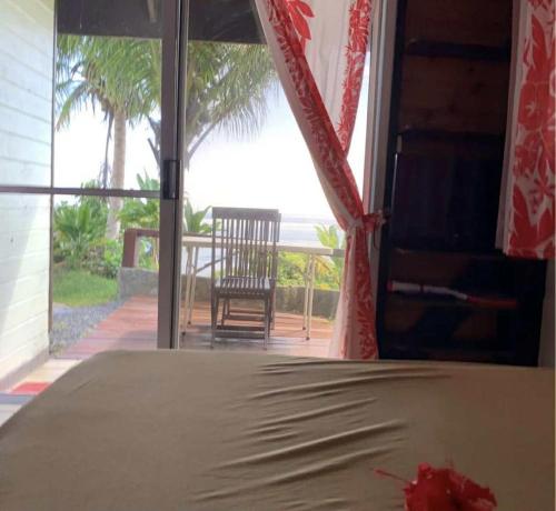 a bedroom with a bed and a view of the ocean at Bungalow studio in Raiatea