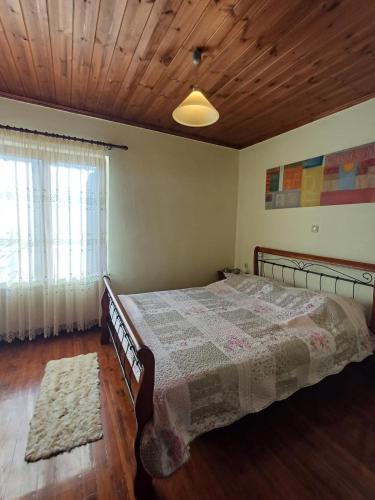 a bedroom with a bed and a wooden ceiling at Gouvas stone house in Karpenisi