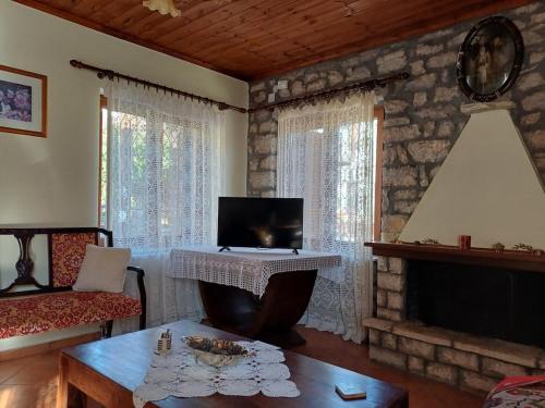un soggiorno con pianoforte e camino di Gouvas stone house a Karpenision