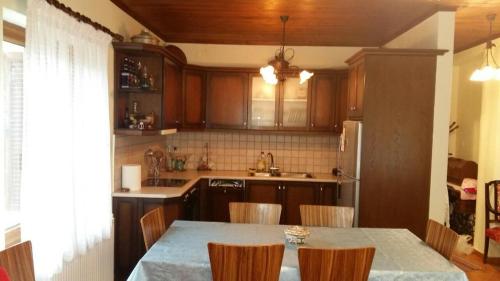una cucina con tavolo con sedie e frigorifero di Gouvas stone house a Karpenision
