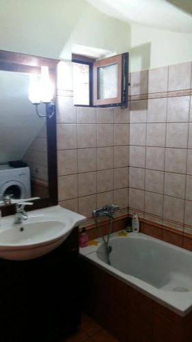 a bathroom with a sink and a bath tub at Gouvas stone house in Karpenisi
