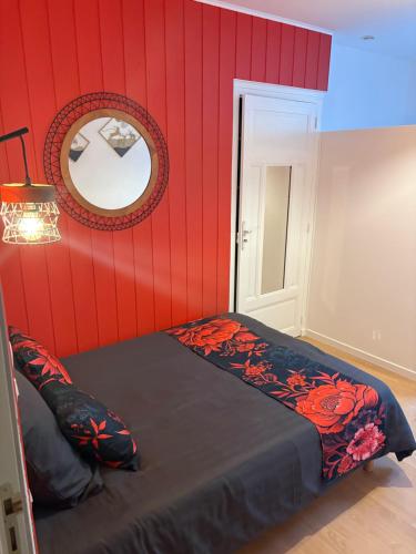 a bedroom with a bed with a red wall at Chez antho chambres et table d hôtes in Betton-Bettonet