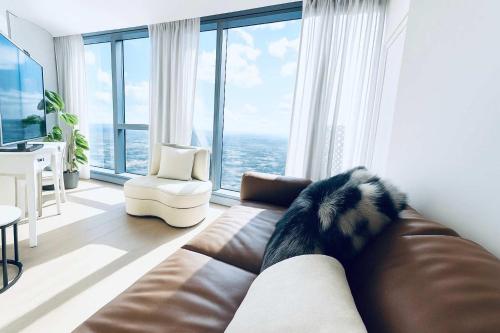 a living room with a couch and a large window at Skyline Grandeur Executive residence by Ritz in Melbourne