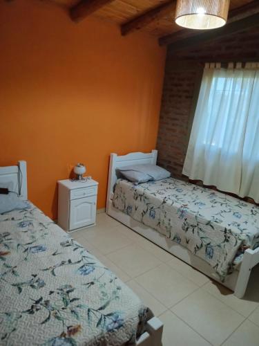 Un dormitorio con dos camas y una ventana. en Cabañas Los 3 Hermanos, en Tanti