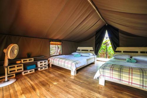 a bedroom with two beds in a tent at Flor y Bambu in Playa Grande