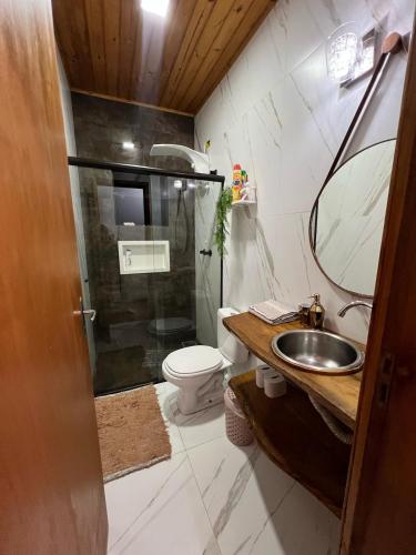 a bathroom with a shower and a sink and a toilet at Refúgio dos Sonhos in Gonçalves