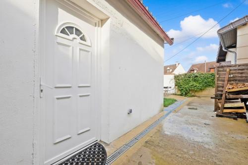 una porta bianca sul lato di un edificio bianco di Gîte de Chalandray a Brunoy