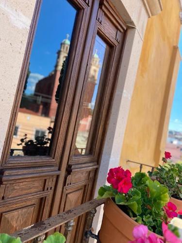 a door with a pot of flowers next to a window at Santuario 71 Lofts and apartments in Guanajuato