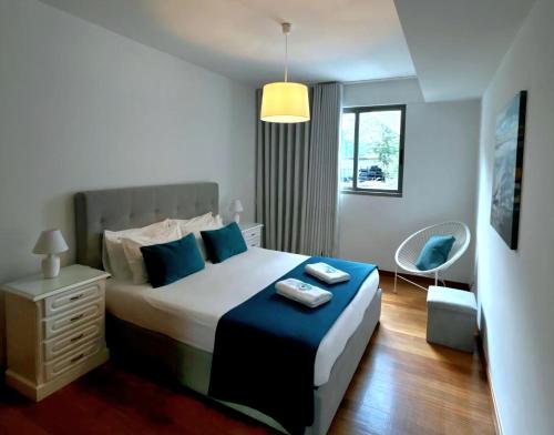 a bedroom with a large bed with blue pillows at Ocean Pearl Apartment V in Funchal