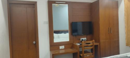 una camera con specchio, TV e porta di Hotel Crossway a Chennai