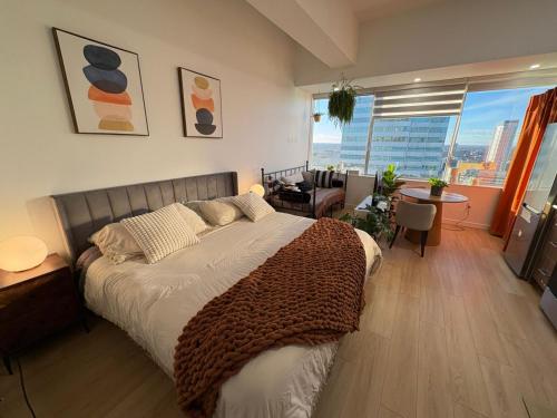 a bedroom with a large bed and a large window at Boho Studio Downtown Rogers Views Heated PK in Edmonton