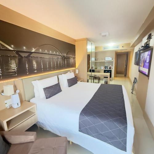 a bedroom with a large bed and a kitchen at Cullinan Brasilia - Fabuloso apt da REDE PREMIUM 13º andar in Brasília